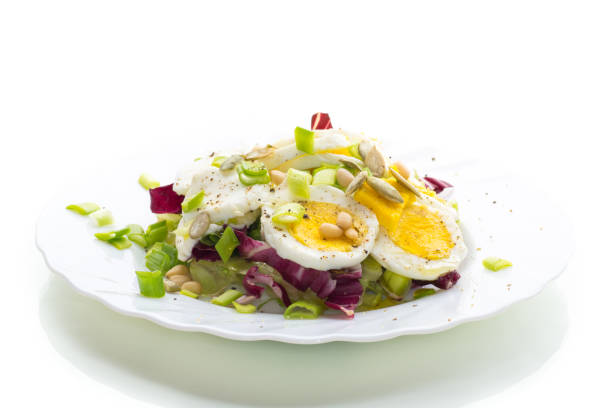 istock Light salad with egg in a plate, isolated on white background 2197846897