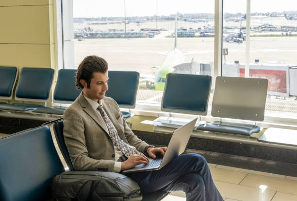 istock Businessman working on laptop while waiting for flight at airport 2197853439