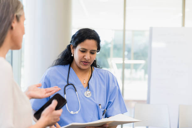 Close up of a nurse holding hand of a patient in hospital ward