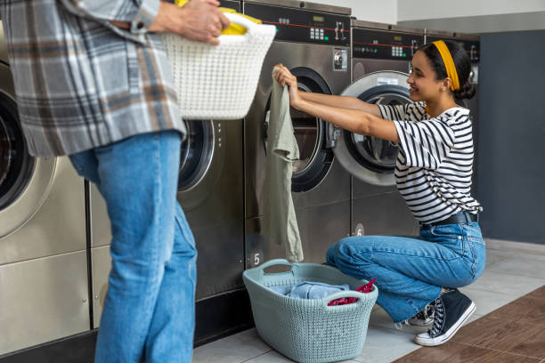 istock Couple in self-service laundromat doing their laundry 2197861262