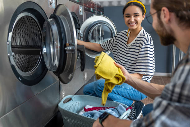 istock Woman and man using a self-service washing machine in public laundromat 2197861273