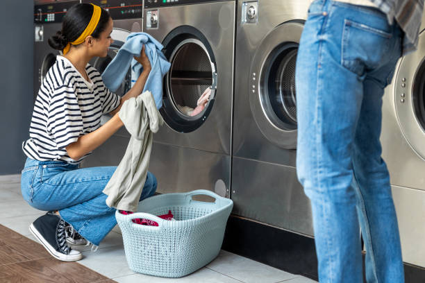 istock Woman and man using a self-service washing machine in public laundromat 2197861275
