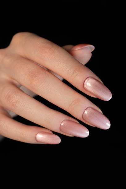 istock Shiny peach-colored magnetic manicure with a soft metallic sheen smoothly transitions, creating a three-dimensional illusion. 2197862049