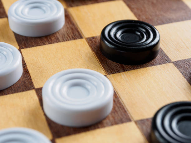 istock Checkers game setup on a checkered board. Strategy, game pieces, black and red, ready to play, board game. 2197863333
