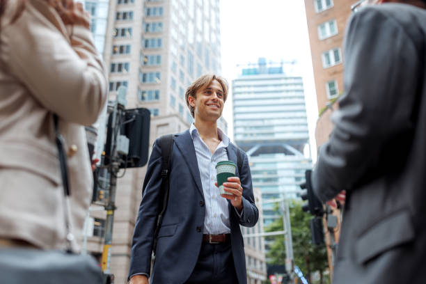 istock Young well dressed businessman talking with his colleagues while having coffee break outdoors in a city 2197869540