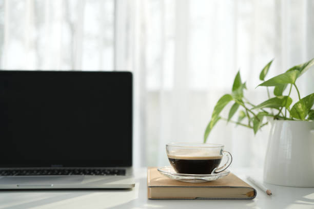istock Laptop and coffee cup on a white desk 2197869923