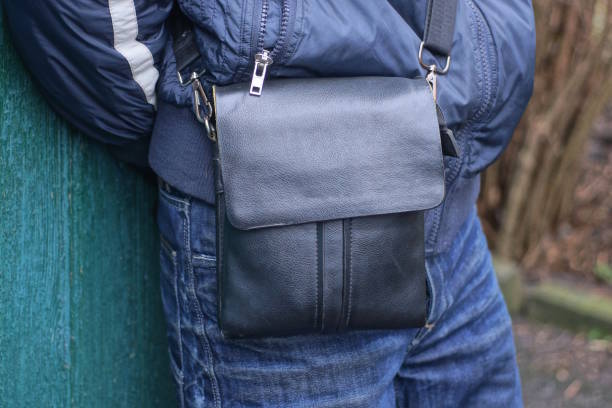 istock one black leather bag hanging on shoulder of man 2197870352