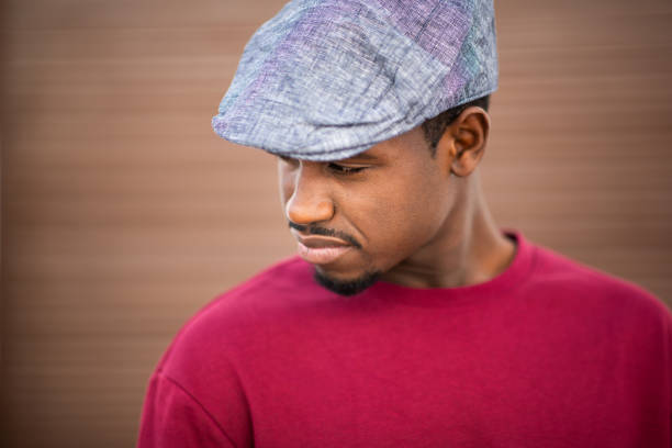 istock Serious young african american man with cap looking down 2197877238