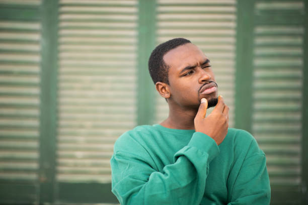 istock Young african american guy looking away and thinking 2197877257