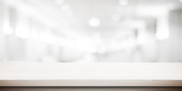 istock Table and blur background, White wooden counter over blur bokeh light background, table top, shelf for food and retail shop, store product display backdrop, banner, mockup, template 2197878864