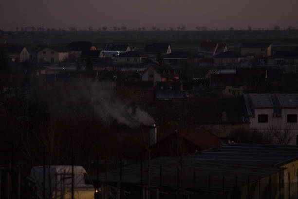 A faroff view of a cityscape at dusk with distinct buildings and urban lights illuminating the surroundings in a tranquil atmosphere