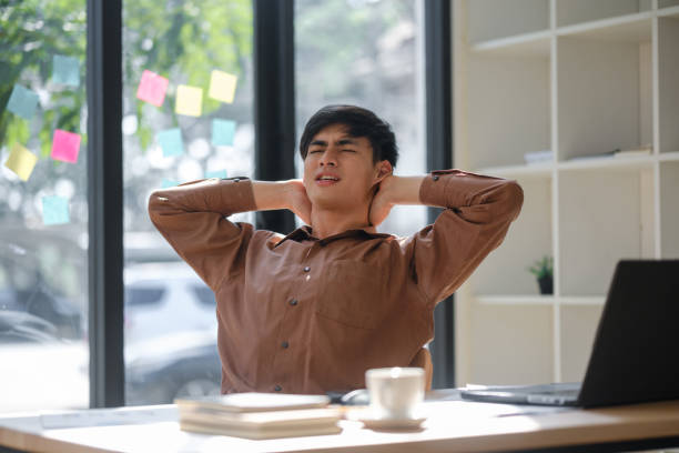 istock Tired office worker experiencing neck and shoulder pain from prolonged work hours 2197885180