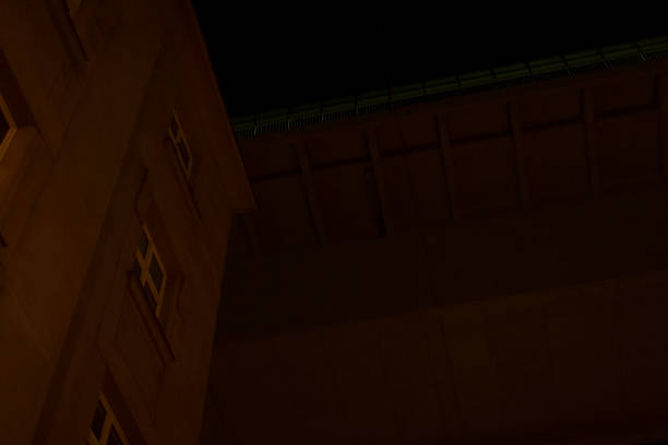 A nighttime urban scene with a key building and a detailed overpass structure as main features