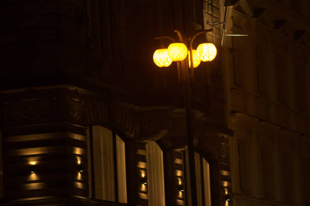 Urban scene at night showcasing a lamppost, a building facade at city.
