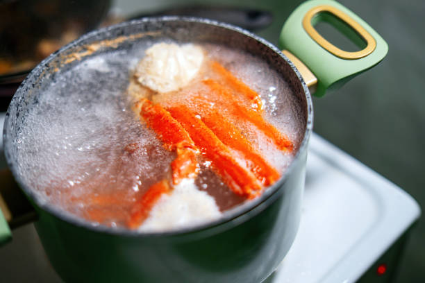 crab claws submerged in boiling water inside a green pot, showcasing the cooking process of fresh seafood. Ideal for culinary, food preparation, and seafood-themed content