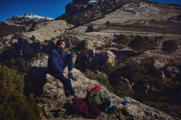 istock Man Enjoying Warm Beverage During a Hike in a Scenic Mountain Landscape 2197890738