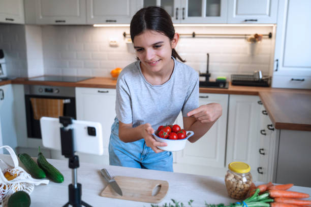 istock Girl Showing Fresh Tomatoes in Bright Kitchen 2197891623