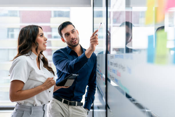Business team brainstorming at the office and pointing ideas on a whiteboard