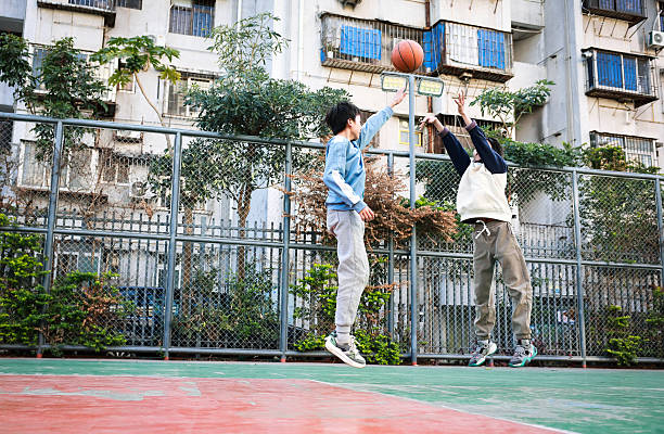 Two young boys playing basketball in a park