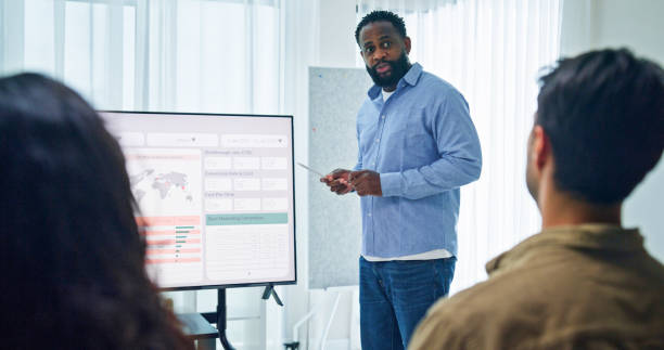 istock Group of business professionals meeting reviewing global data analytics discussing data analytics during a presentation, discussing strategy and growth standing at the office. Finance meeting concept. 2197902492
