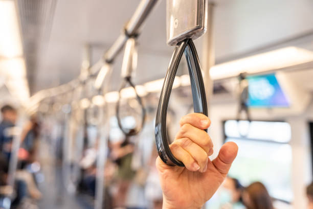 istock Close up of human hand holding strap inside the metro train. Blurred copy space background. Passenger safety in public city transport 2197910852