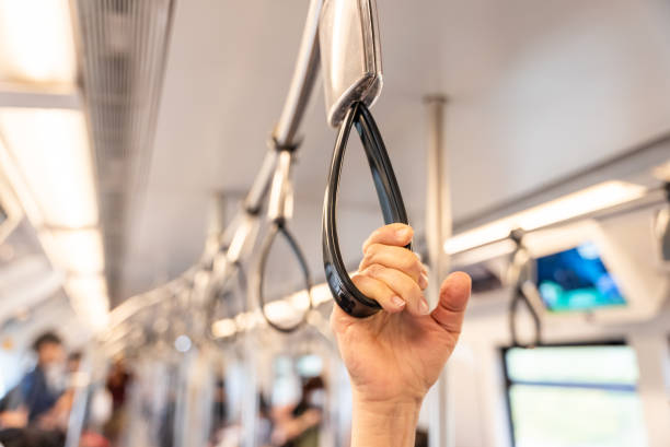 istock Close up of human hand holding strap inside the metro train. Blurred copy space background. Passenger safety in public city transport 2197910913