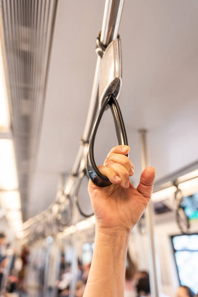 istock Vertical close up of human hand holding strap inside the metro train. Blurred copy space background. Passenger safety in public city transport 2197910995