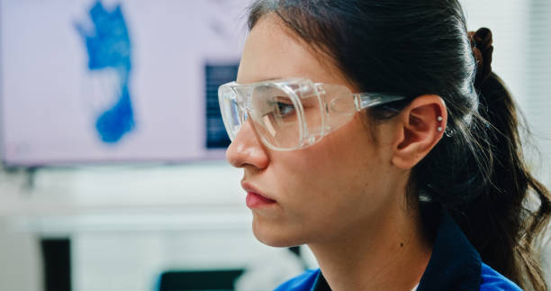 Closeup Young female engineer work on controlling robotic arm in tech lab. Display AI and robotics hand design operates machinery and analyzes data for innovation. AI and Robotics Development concept.