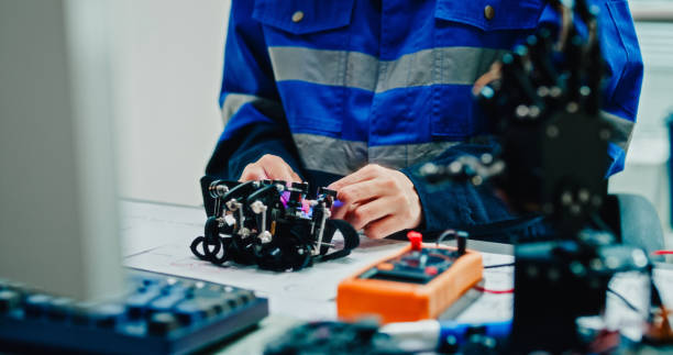 istock Close-up of Young female engineer examining and working on a robotic arm prototype in technology laboratory. AI and Robotics Development. 2197913303