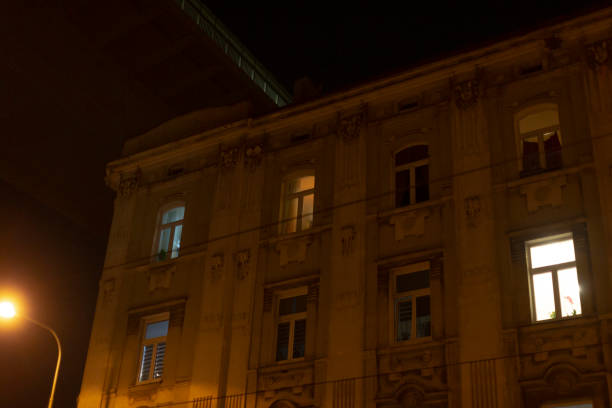 istock A large building filled with numerous windows shines brightly at night 2197913546