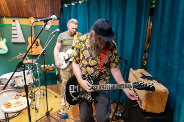 istock Rock musicians tuning guitars in a recording studio 2197914530