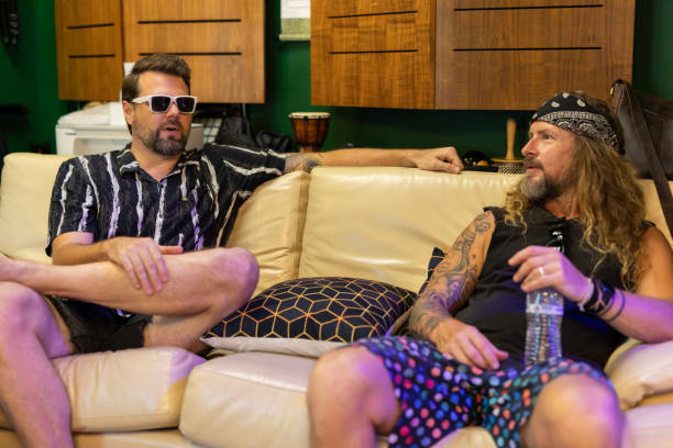 istock Middle aged rock musicians relaxing on a sofa together 2197914591