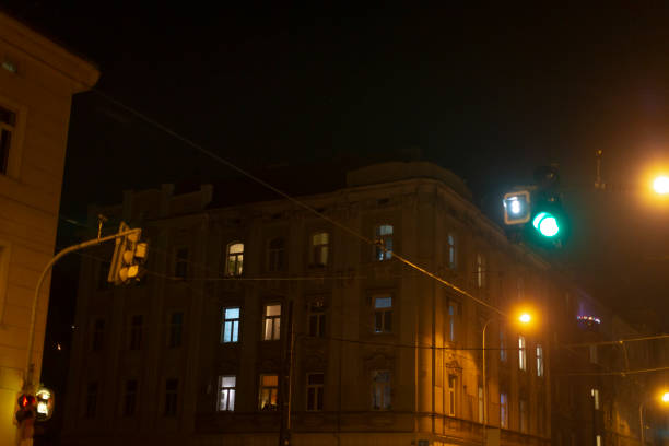 A somewhat unclear and blurry image depicting a street scene at nighttime adorned with a bright green light illuminating the surroundings
