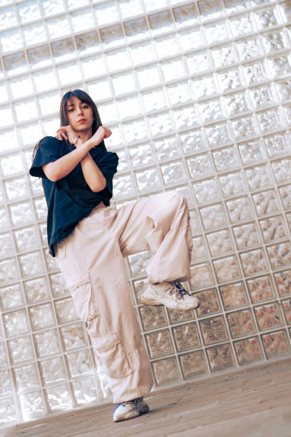 istock Stylish dancer showcases unique choreography against a textured glass wall in an urban setting 2197914902