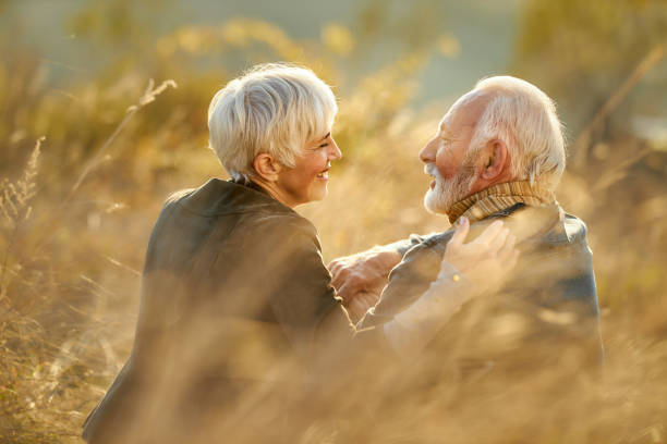 istock Happy senior couple talking during autumn day in tall grass. 2197916743
