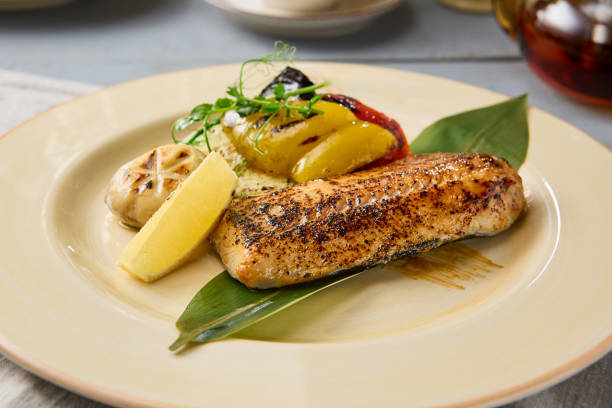 istock Grilled White Fish Steak with Vegetables A Rustic Feast in Warm Tones 2197916746