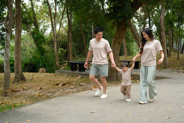 istock Loving family walking together on a paved path surrounded by trees 2197917443
