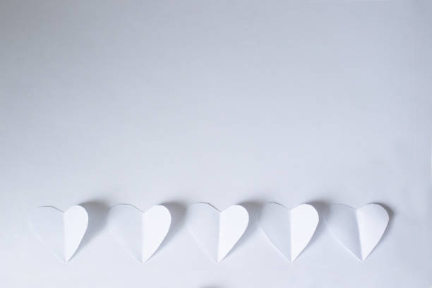 istock White paper cutting hearts on white paper background 2197919454
