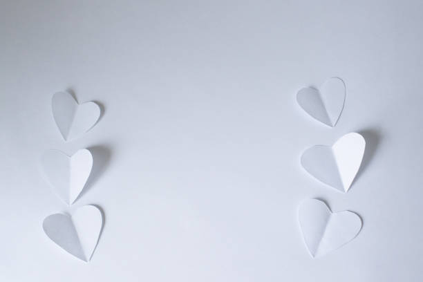 istock White paper cutting hearts on white paper background 2197919458