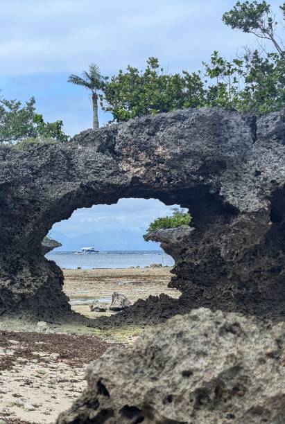 istock Small boat framed by rock formation, Moalboal 2197919996