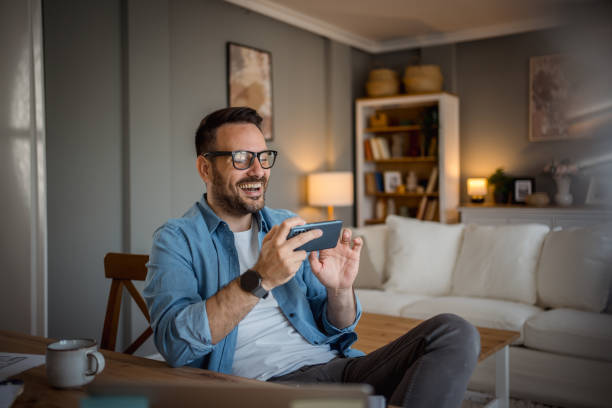 istock Businessman playing mobile phone games in home office 2197920066