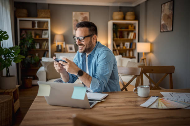 istock Businessman playing mobile phone games in home office 2197920069