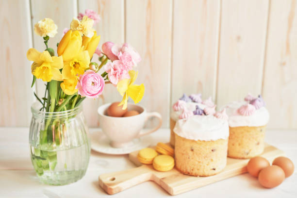 Easter composition with sweet bread, Easter cake, eggs, bouquet of flowers. Holidays breakfast concept with copy space. Traditional easter cake with gingerbread cookies. Easter Greeting Card Template.