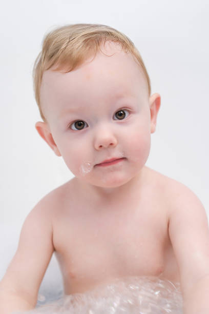 cute asian Baby boy having a bath with his love mom in garden with swimimg pool in background