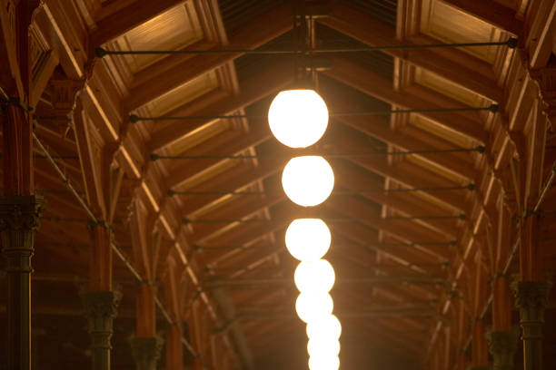 A stylish pendant light fixture radiantly glowing and contrasting beautifully against urban backdrop at night.