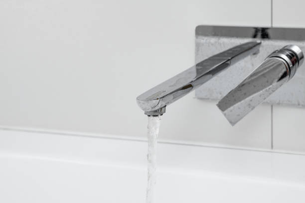 istock Water flows from an open tap into a bathtub in a bathroom close-up 2197926286
