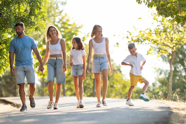 istock Happy family strolling in sunny park together 2197926798