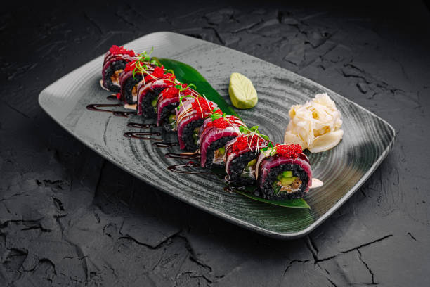 istock Colorful sushi rolls served on a decorative plate with garnishes in a modern restaurant setting 2197928115