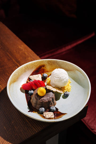 istock Delightful dessert featuring chocolate cake, fresh fruits, and ice cream served on a rustic plate at a cozy restaurant 2197929323