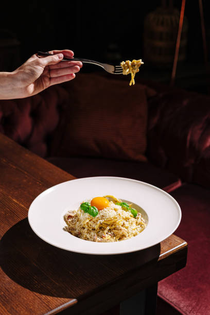 Delicious pasta dish served with fresh ingredients and a vibrant egg yolk in an upscale restaurant setting